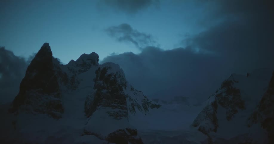 The mountains are dark and covered in snow