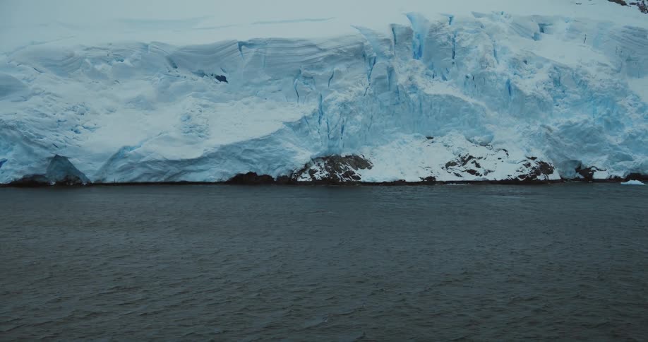 Mountain covered under a thick layer of ice next to the ocean