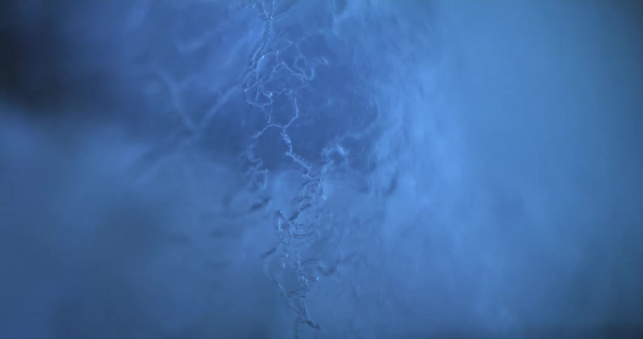 Close up of the cracked surface of an ice sculpture reflecting blue light