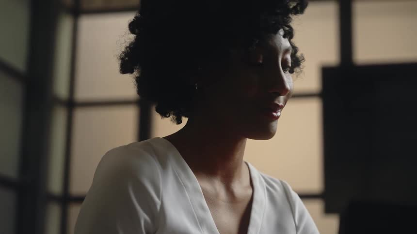 A woman smiles as she greets a person on a call in her office