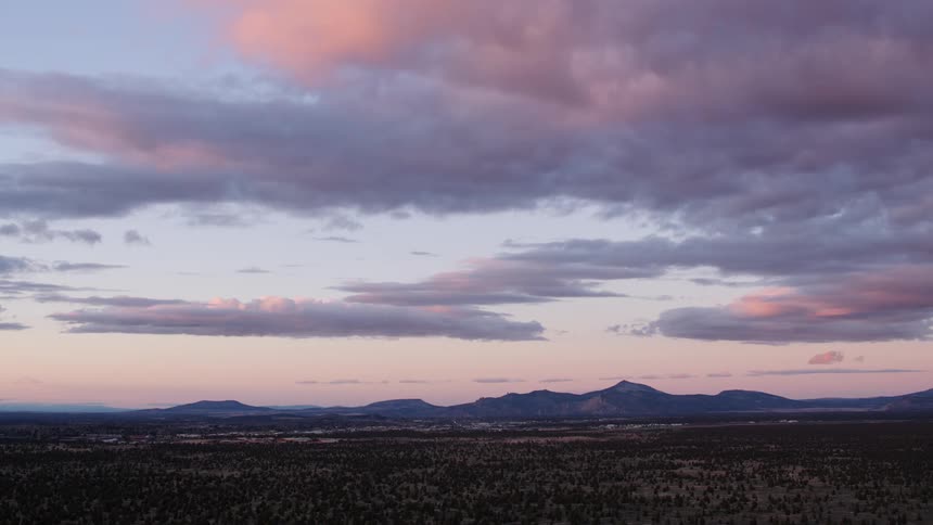 A mountain range stands in the distance under a cloudy sky