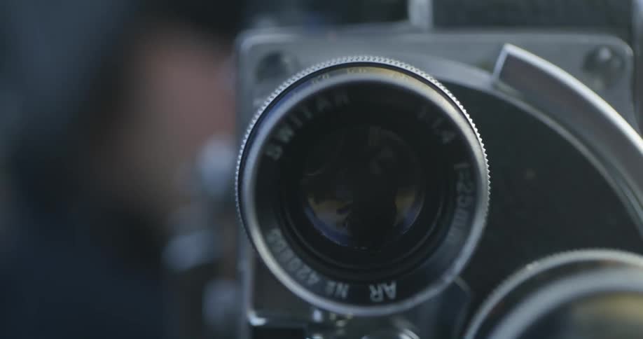 A photographer adjusts the lens on a vintage film camera