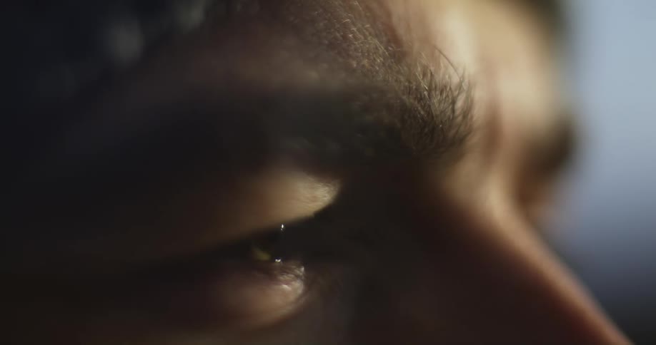Close up of the eyes and forehead of a man outdoors at evening