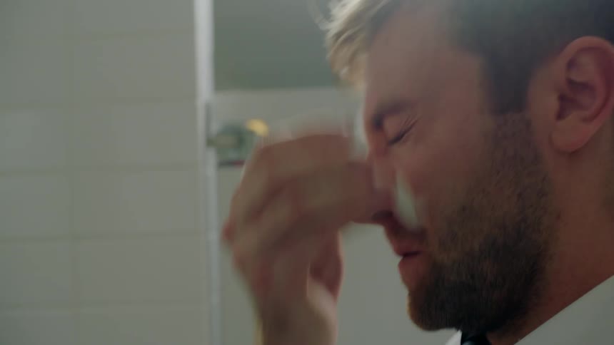 A man washes his face in the bathroom