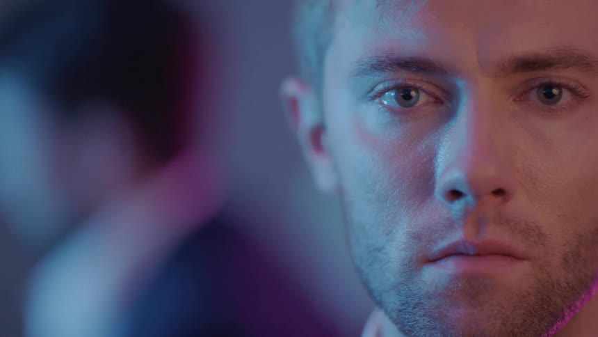 A man is staring forward near a group