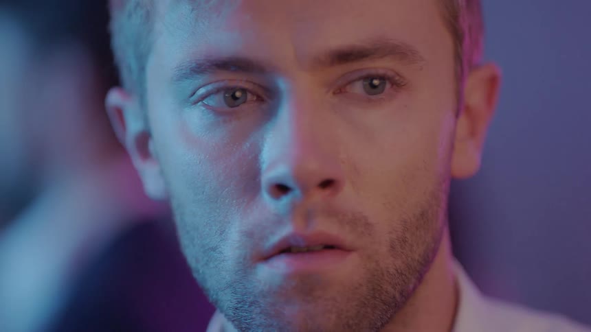 A man is blinking and looking around