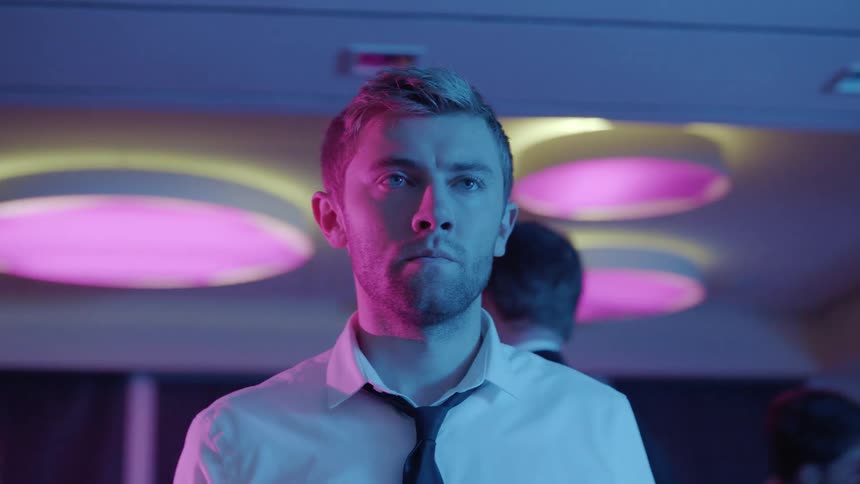 A man is standing in a room with a group of people