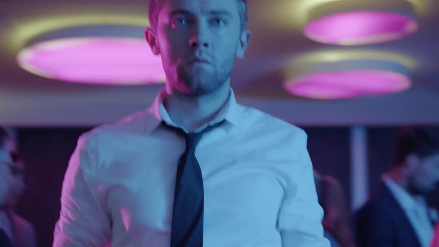 A man is holding a bottle at a party
