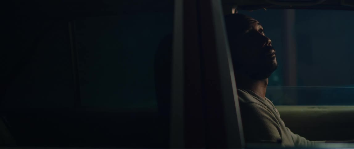 A man sits in his parked car at night