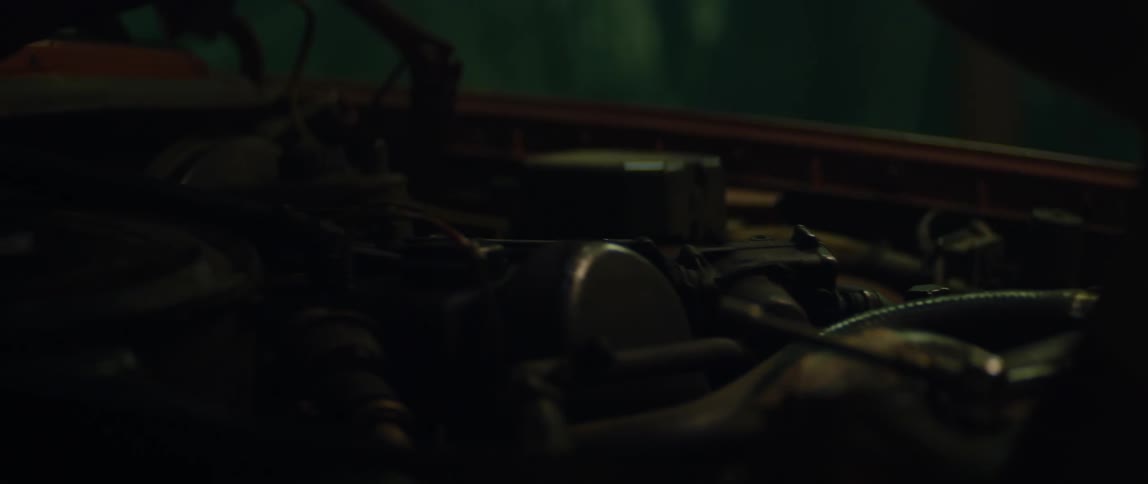 A man working on an old beat up car