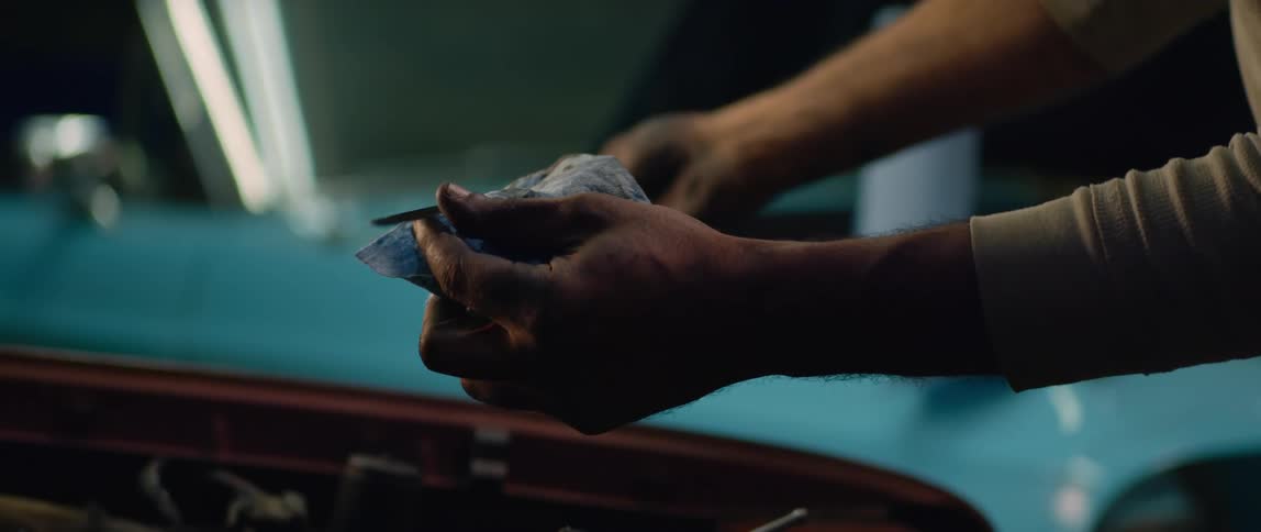 A man looks at an oil stick as he checks his oil