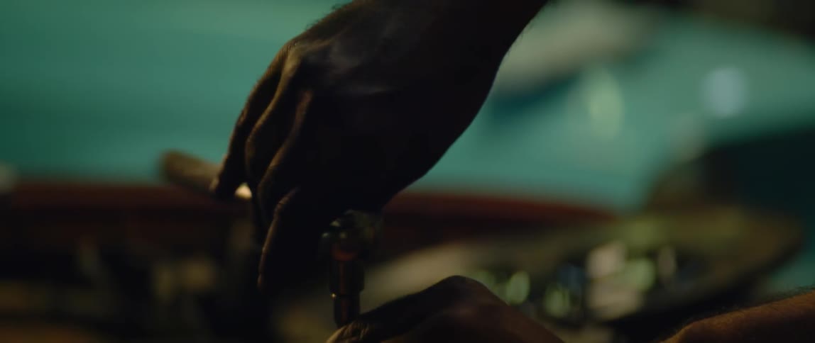 A man uses a socket wrench while working on his cars engine