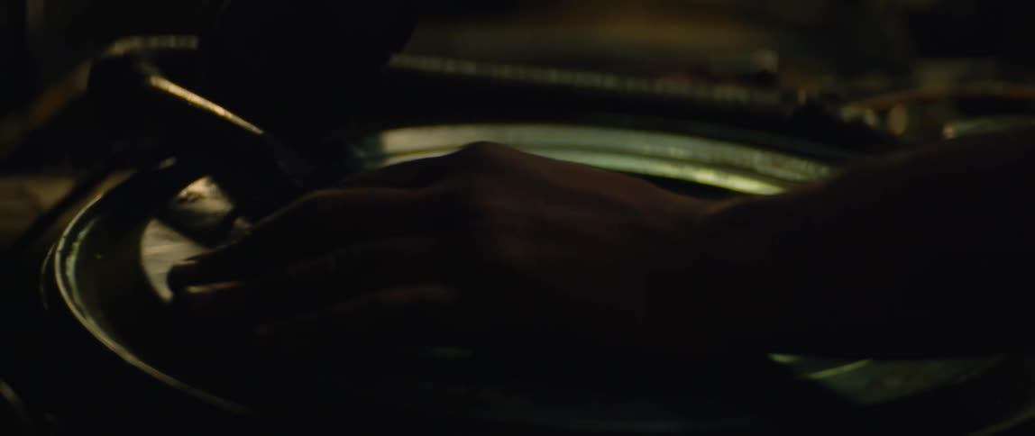 A man is removing a car part at night