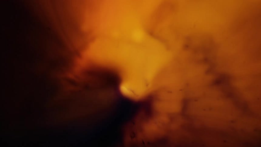 A perfect circle of light surrounded with bright yellow and orange and swirls of brown