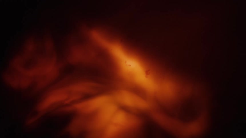 A light glows behind an orange fluid pattern