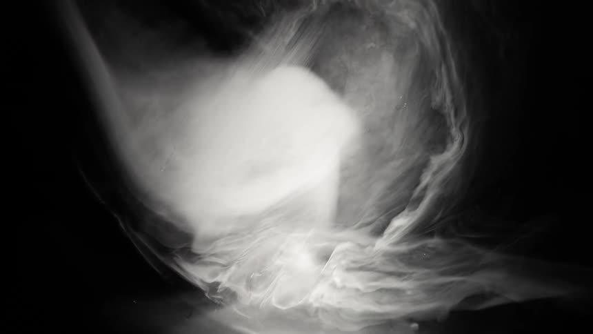 Smoke falls then collapses onto itself in the darkness