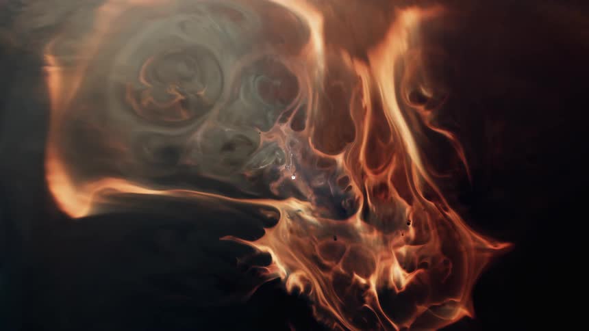 Gray smoke swirls and rises from bright orange flame