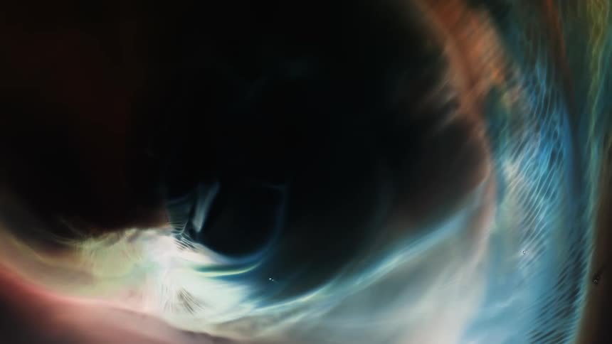Wisps move as they grow around the edge of an organic environment as it moves across the darkness