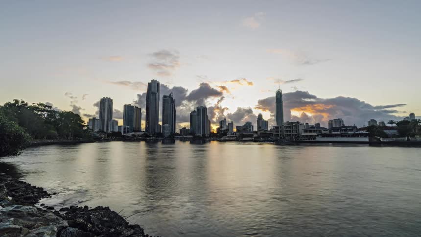 The sun rises over a large city on the waterfront