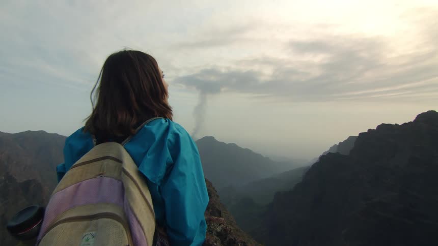 A woman is hiking in a mountainous area