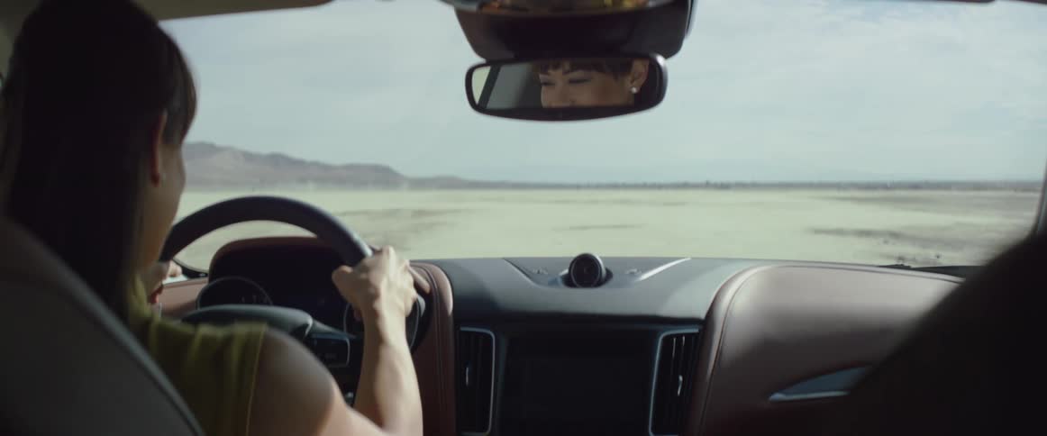 A woman is driving a car in a rural area