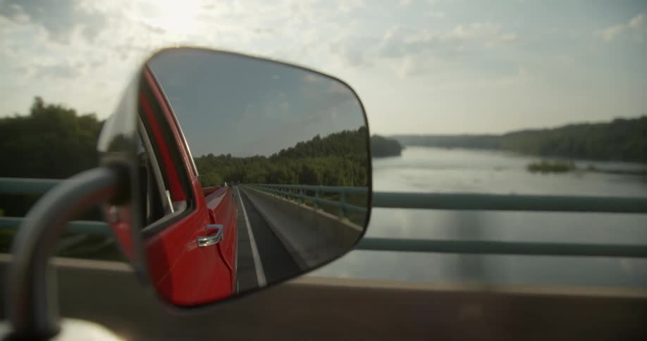 A pickup truck drives on a bridge over a river