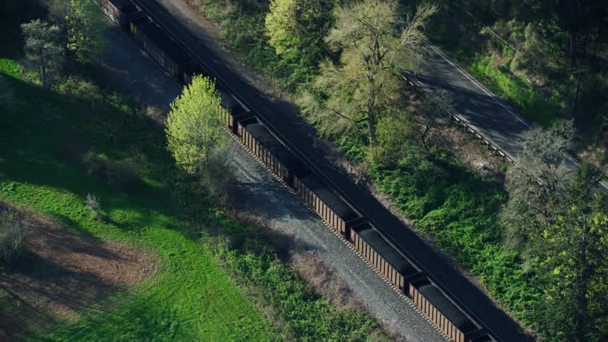 A coal freight train barrels down the Columbia River Gorge hauling coal in open freight cars