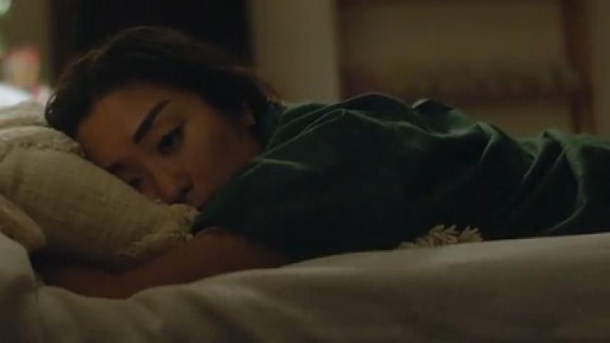 A woman jumps into bed and buries her face in her pillow