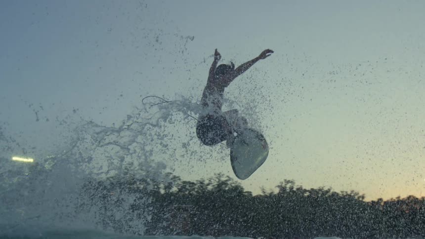 A surfer jumps off a large wave