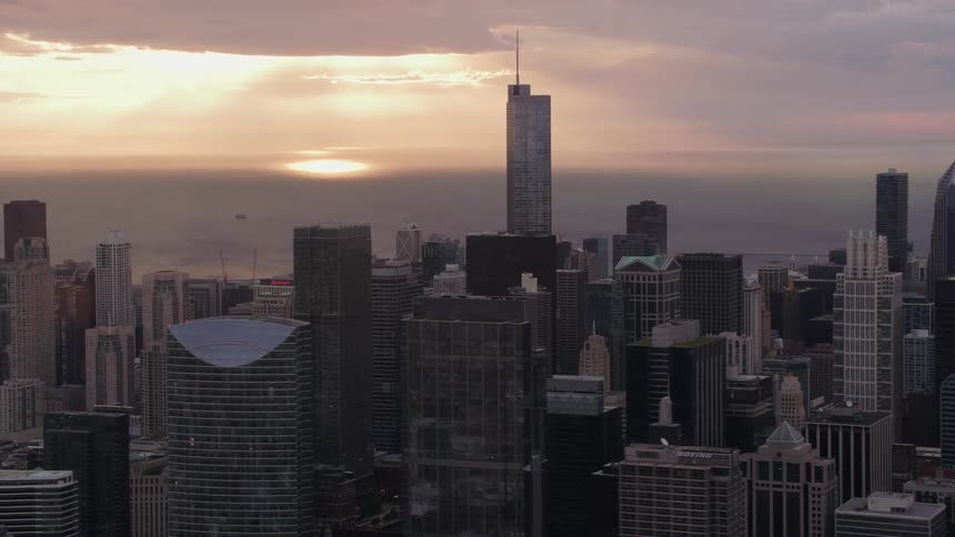 An aerial view of skyscrapers in a city at sunset