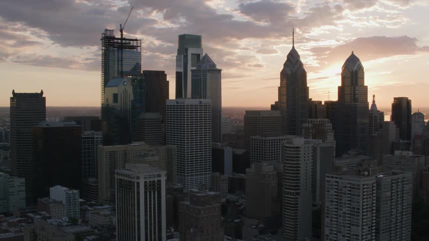 The bright sun rises and shines on the city buildings