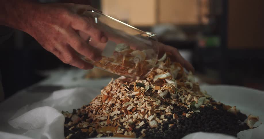 A person empties a jar of orange peels