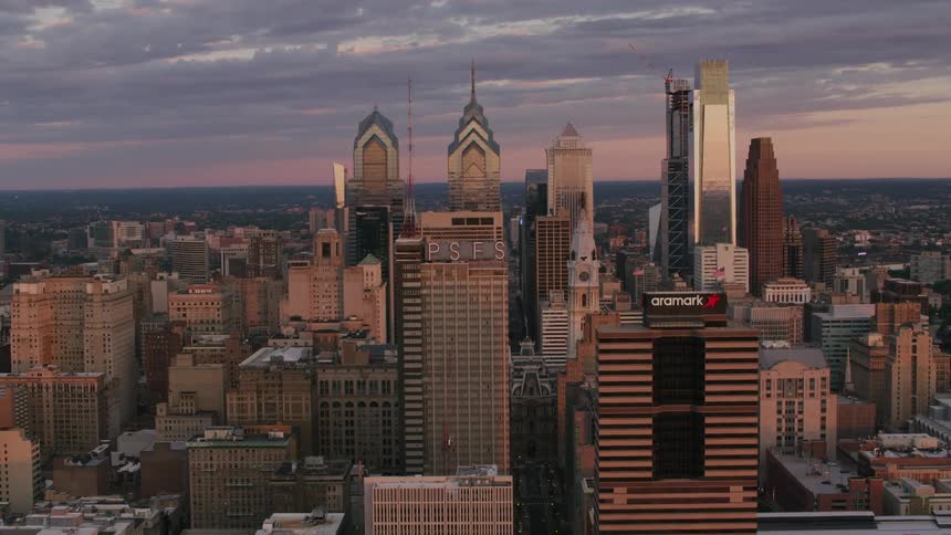 Towers and skyscrapers stand tall in a big city skyline under a cloudy sky