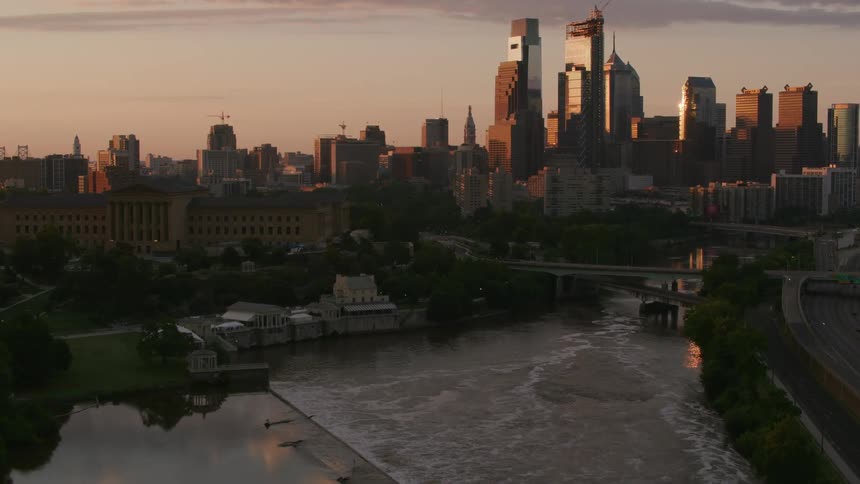 Aerial view of city river with skyscrapers in the background at dusk