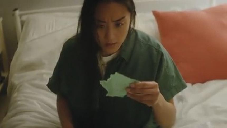 A girl throwing a discouraging note onto a bed