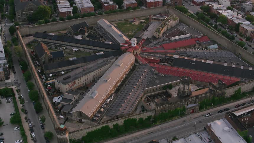 Aerial view of a penitentiary surrounded by walls and the neighboring buildings in the town