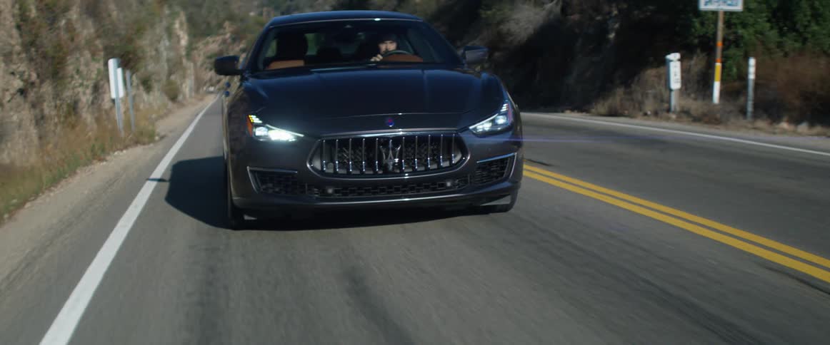 A man driving a car on a paved road