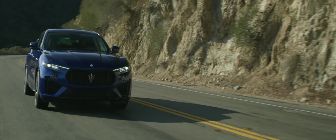 A vehile drives along a curve on a mountain road