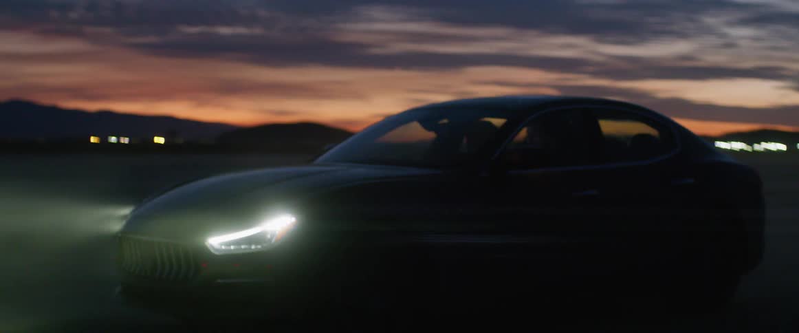 A car being driven on a road at dusk