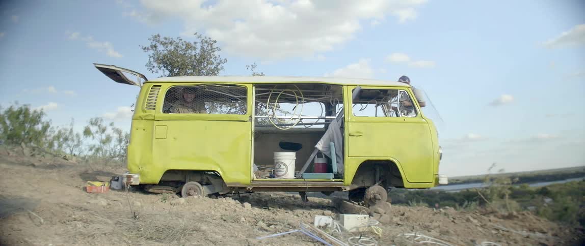A man is working on a yellow van