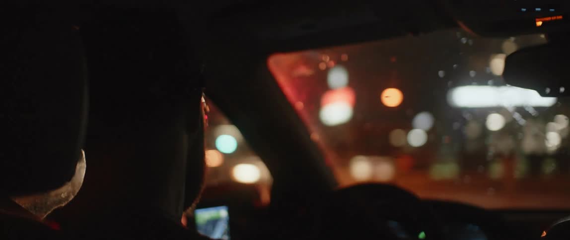 A man checks his smartphone while driving through downtown