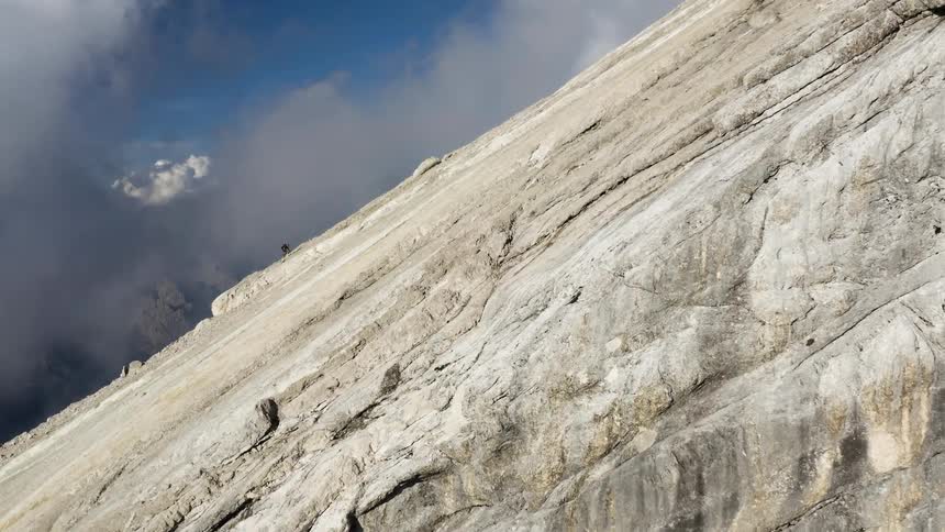 A person rock climbs up a cliff