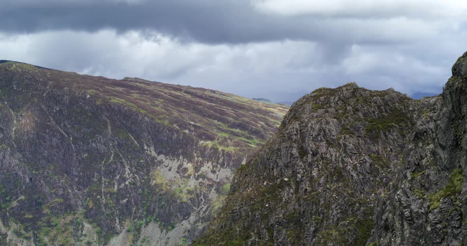 A mountain range under a cloudy daytime sky