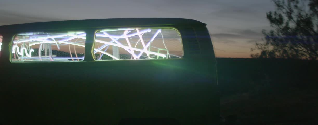 A van has bright lights inside at dawn
