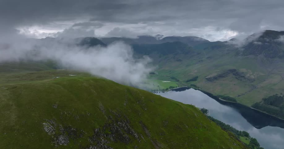 A verdant mountain valley below a mountain ridge covered in vegetation on a cloudy day