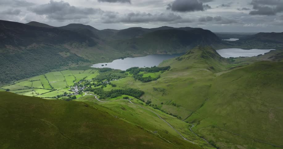 Aerial view of a small town nested in a valley between mountains next to a lake