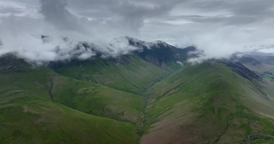 Dense clouds move over rolling hills and mountains