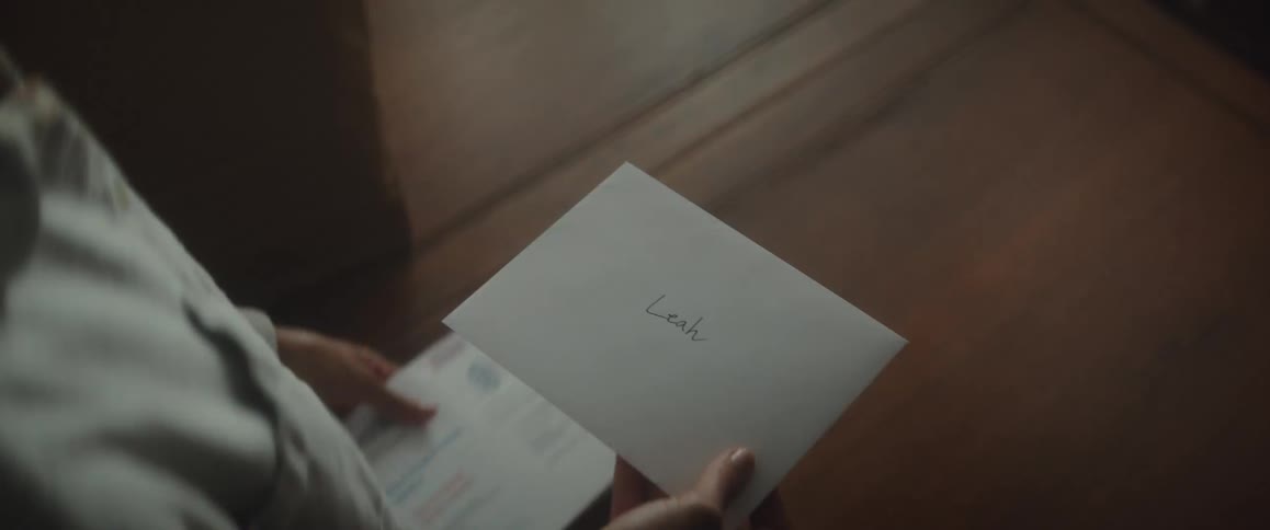 A young woman picks up the mail and sees a handwritten letter from a family member