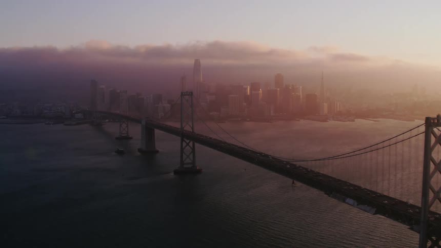 Heavy fog sets in as traffic passes down a bridge toward downtown