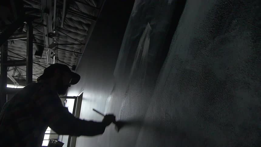 Man paints a wall indoors